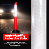 High-visibility reflective strip on a road with a car's headlights