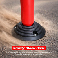 Red bollard with a black base on a textured surface