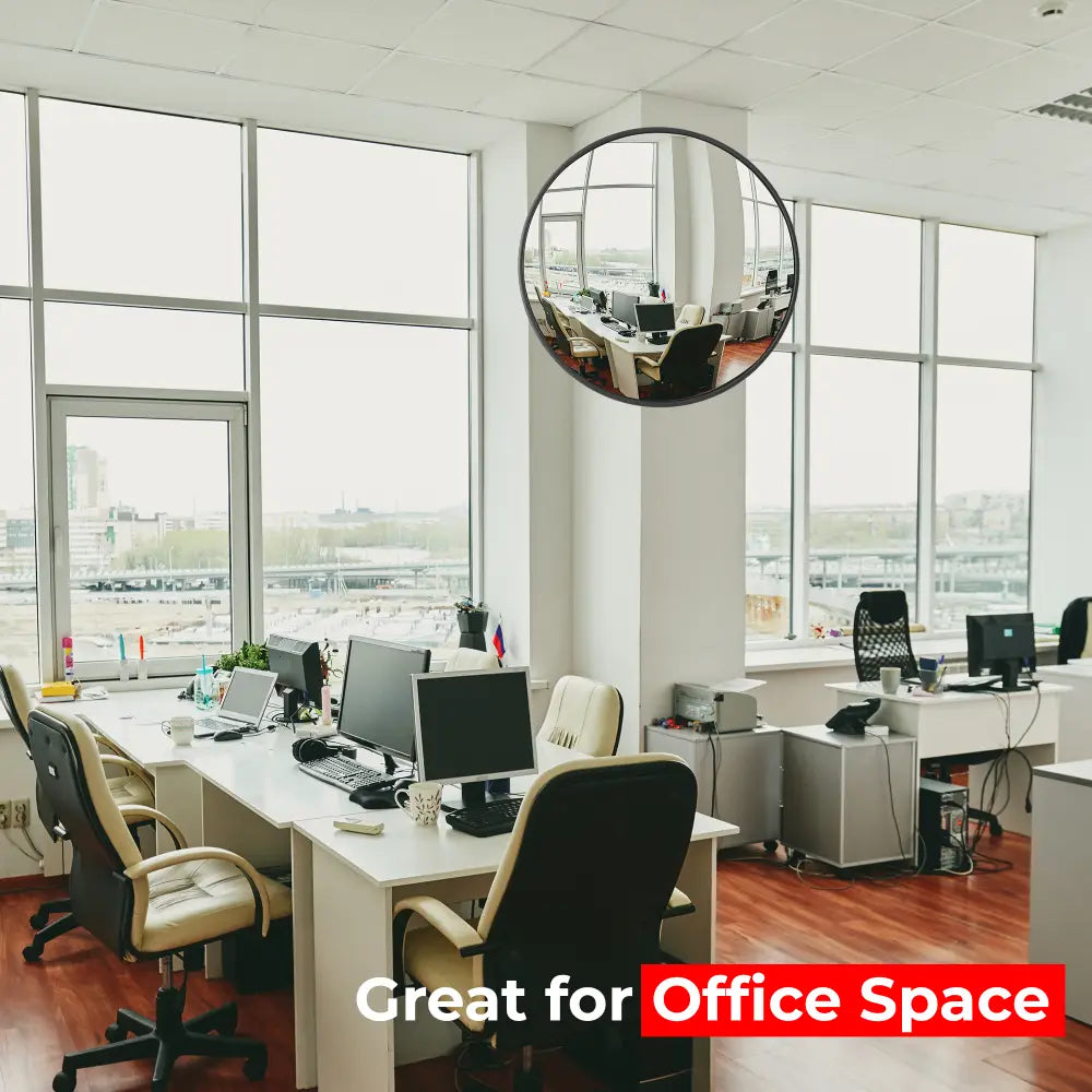 Modern office space with large windows and desks with computers.