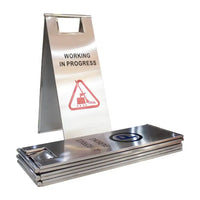 Metal sign with 'Working in Progress' text and warning symbol