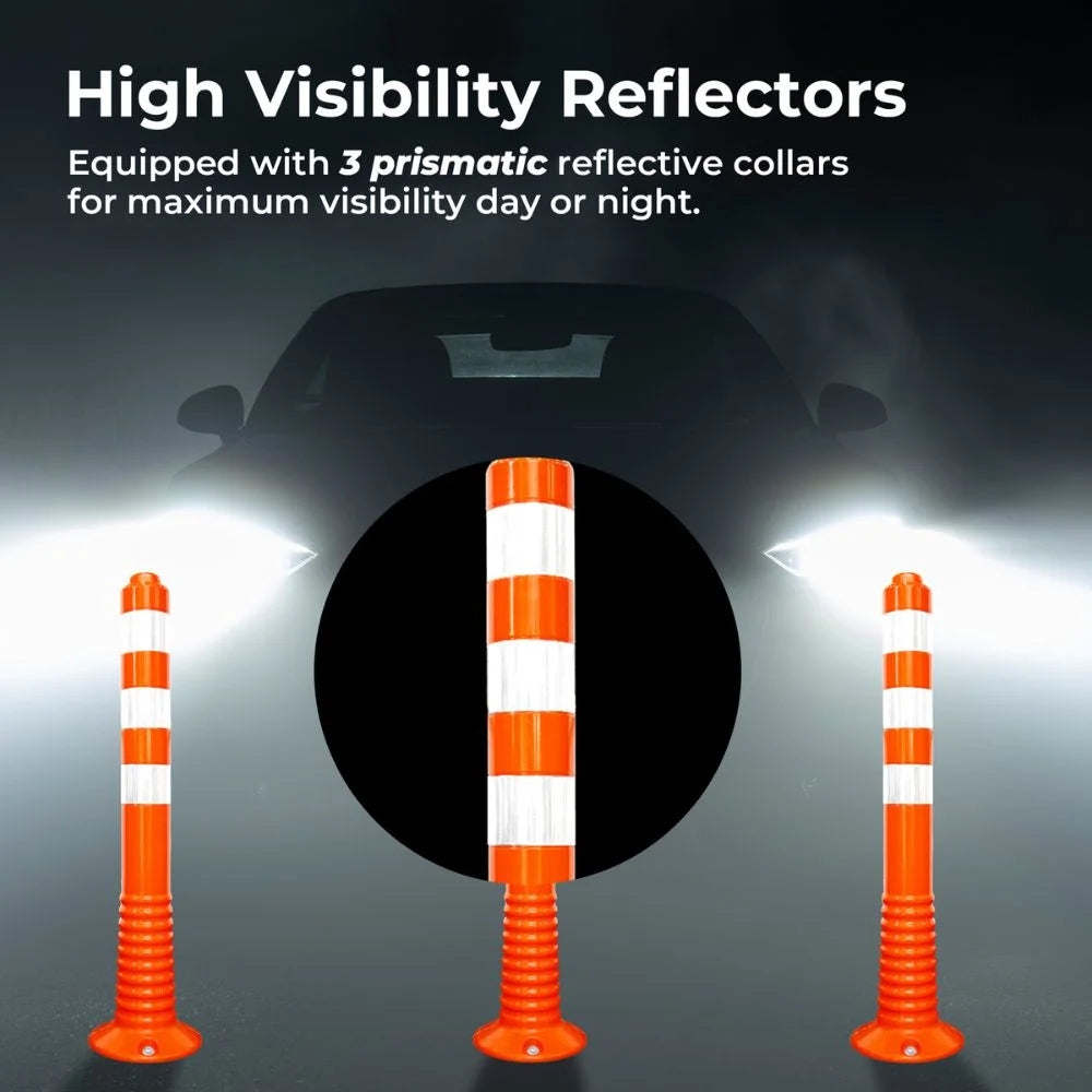 Orange traffic barriers with reflective collars illuminated by car headlights on a dark background.