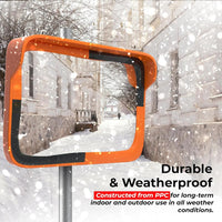 Orange and black rectangular mirror in a snowy urban setting