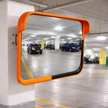 Orange safety mirror in a parking garage reflecting 