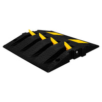 Black rubber speed bump with yellow reflective stripes on a white background