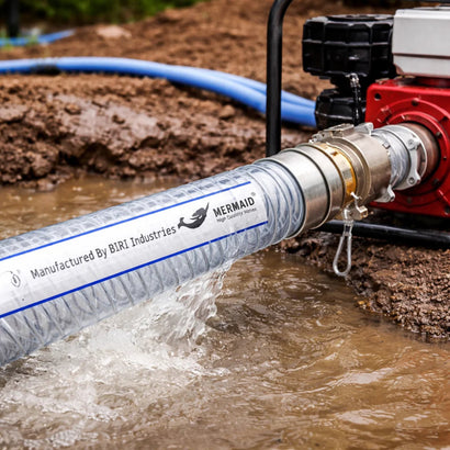 Mermaid hose being used with a pump in a muddy outdoor setting