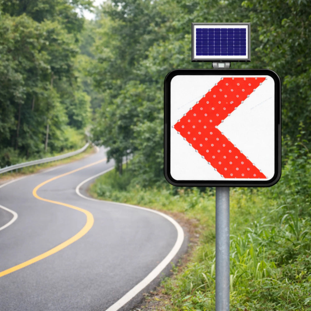 Road sign with a red leftward arrow on a rural road with solar panel