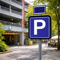Parking sign with solar panel in front of a building