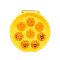 Yellow round reflective safety light with multiple lenses on a white background