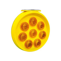 Yellow round reflective safety light with multiple orange lenses on a white background