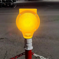 Yellow warning light on a pole in an outdoor setting